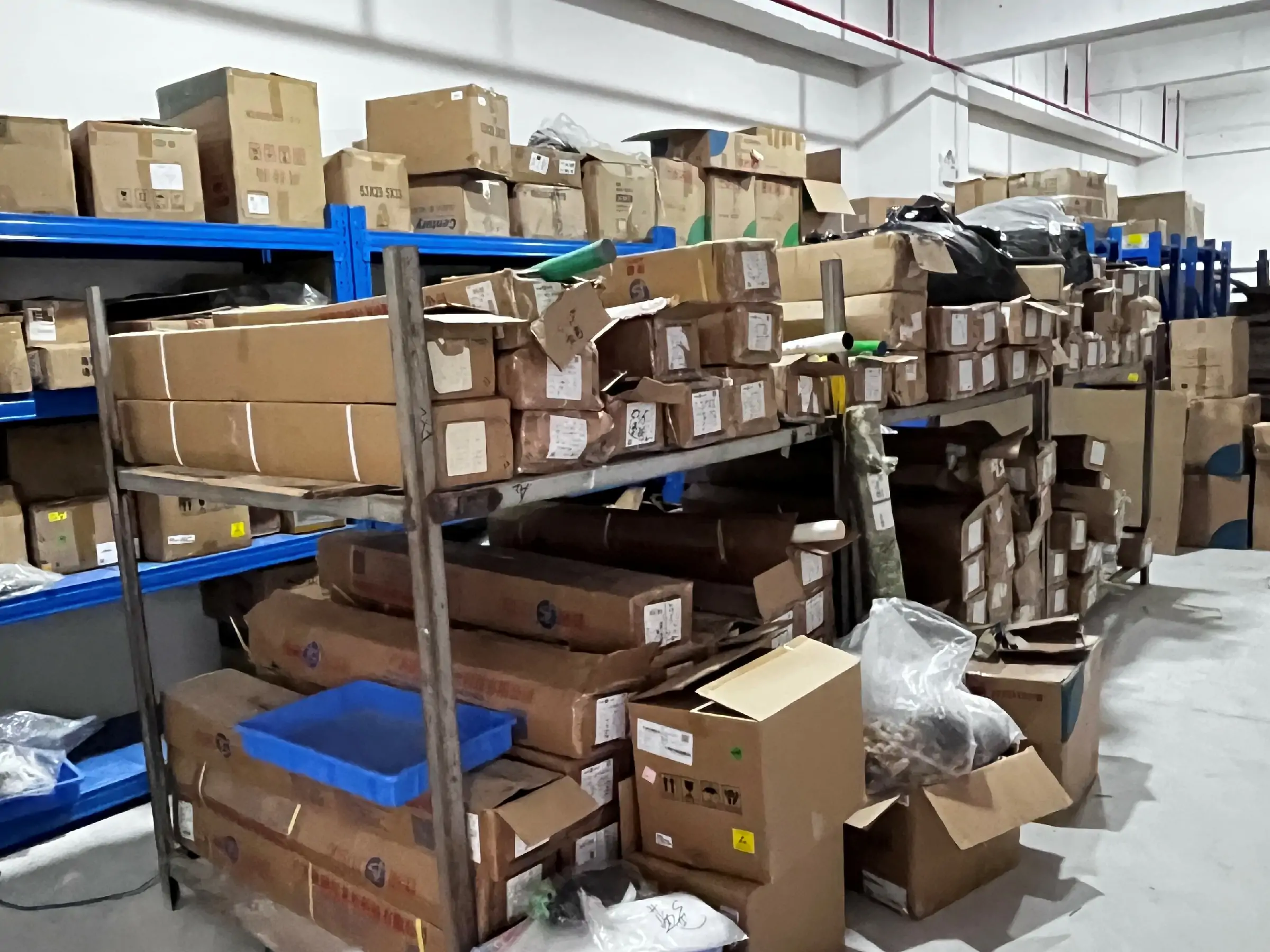 Brush inventory, production materials, and packed goods stored on warehouse shelving.