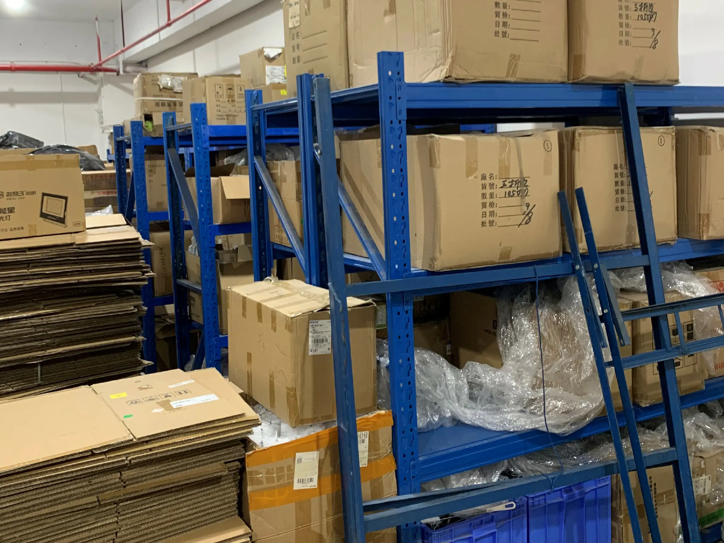 Brush manufacturing warehouse with boxed products, production materials, and completed orders staged for storage and shipment.