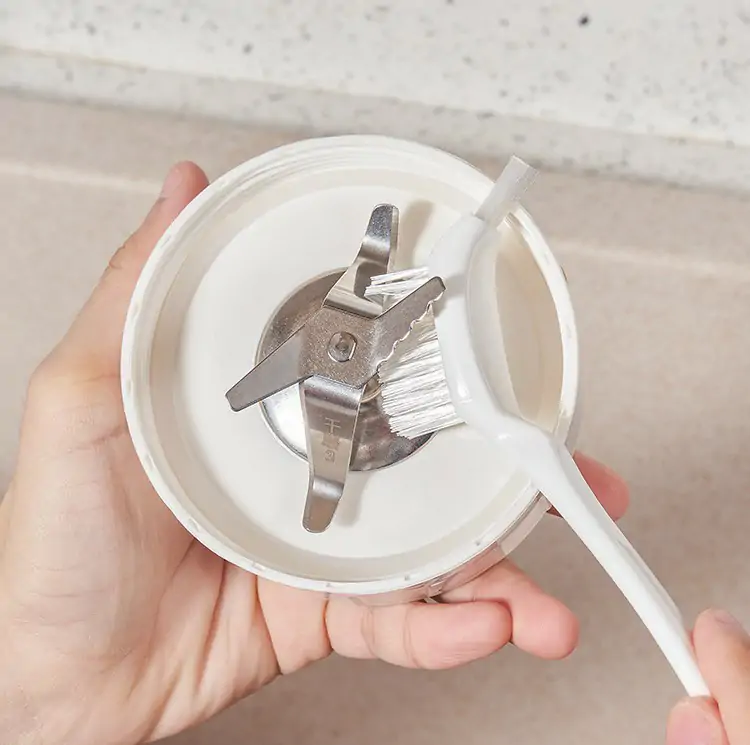 Blender brush with a narrow head for reaching between blade hubs and jar walls