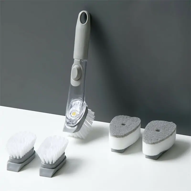 Soap dispensing dish brush with a replaceable head and a handle reservoir